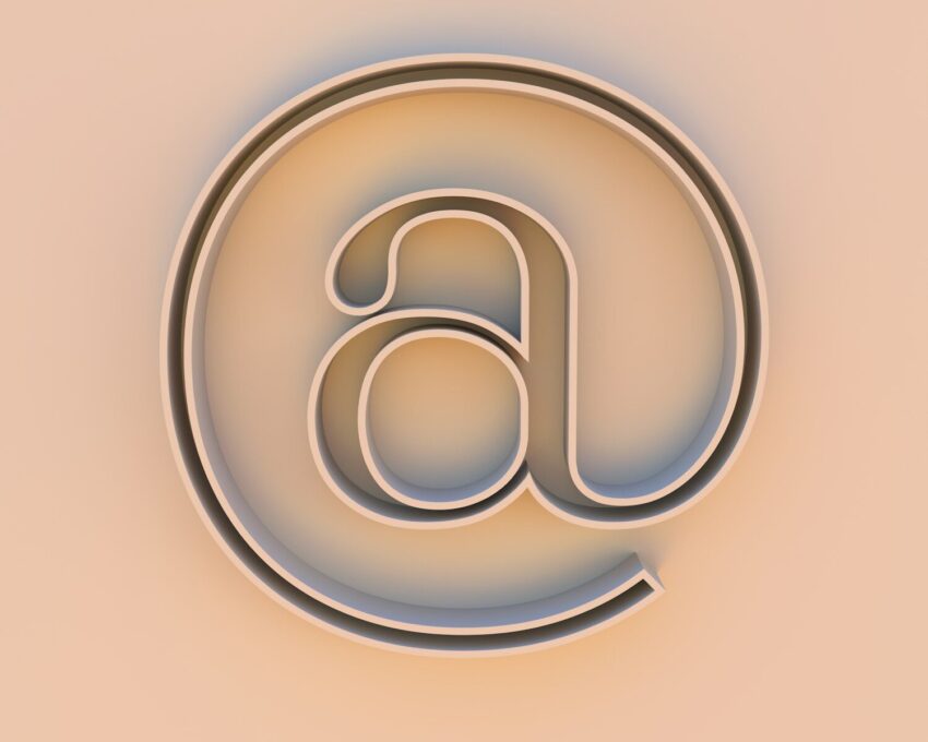An "at" symbol on a beige background.